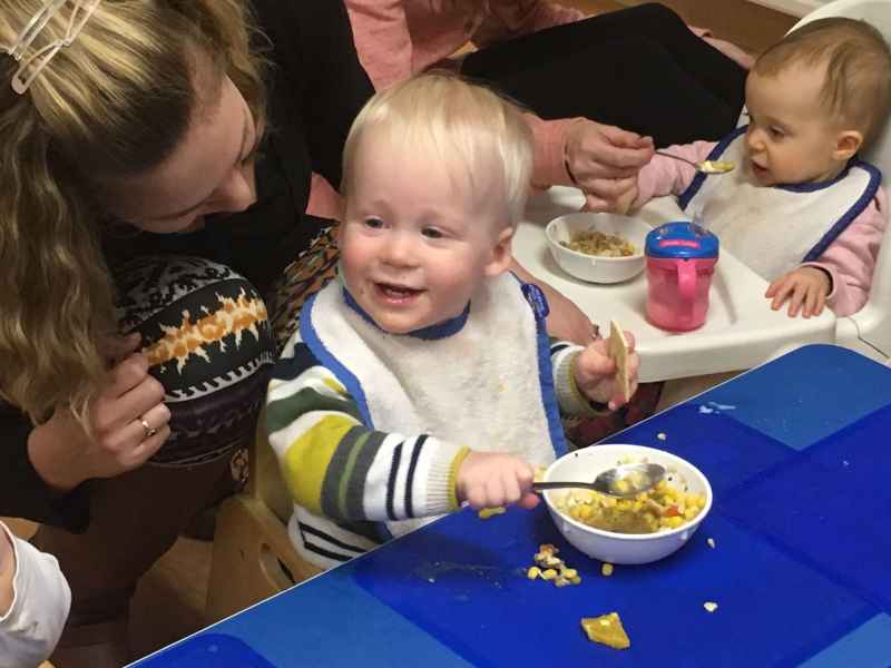 educator with infant while they eat